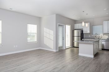 A modern kitchen with a white island and stainless steel appliances.